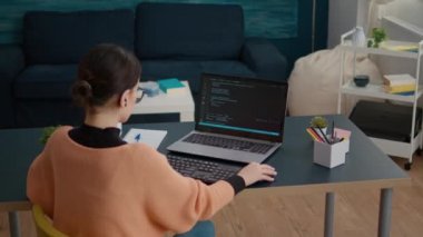 Laptop ekranında ikili kod programlayan genç bir kadın.