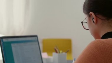 Dizüstü bilgisayardaki akademik araştırma istatistiklerini analiz eden genç bir yetişkin