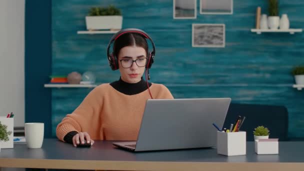 Üniversite öğrencisi çevrimiçi derse katılmak için kulaklık ve laptop kullanıyor. — Stok video