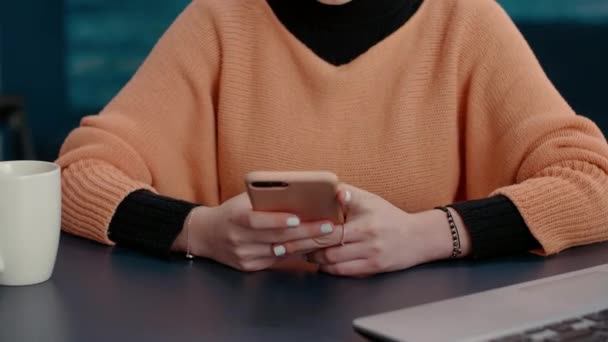 Mujer alegre navegar por Internet en el teléfono inteligente en el escritorio — Vídeos de Stock