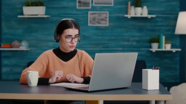 Kulaklıklı bir kadın internet üzerinden konuşuyor.