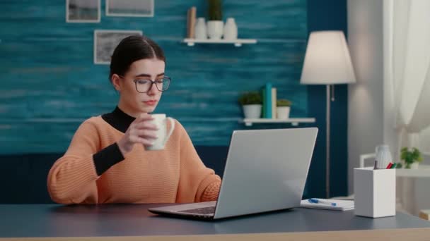 Young adult browsing internet on laptop to do remote school work — Stock Video