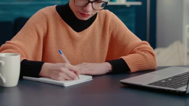 Portrait of woman smiling and writing course report on notebook — Stock Video
