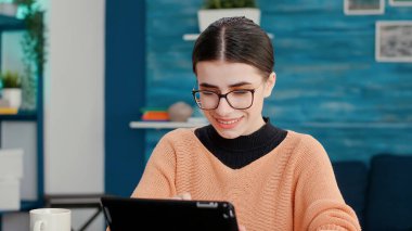 Gülümseyen kadın ders notları almak için dijital cihaz kullanıyor.