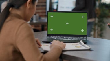 Tekerlekli sandalyedeki eleman yeşil ekranlı dizüstü bilgisayar kullanıyor.