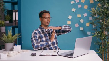 Yorgun işçi dizüstü bilgisayarın önünde mola tabelası yapıyor.