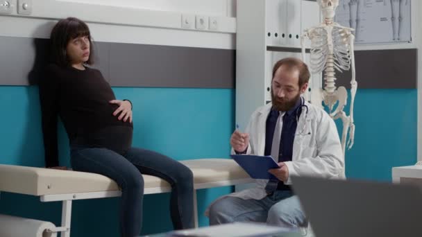 Mujer joven embarazada y reunión con el médico — Vídeo de stock