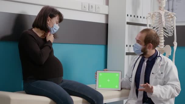 Доктор тримає планшет з горизонтальним зеленим екраном під час перевірки — стокове відео