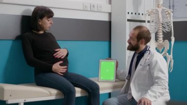 Hamile hasta ve doktor yeşil ekran görüntüsünü analiz ediyor
