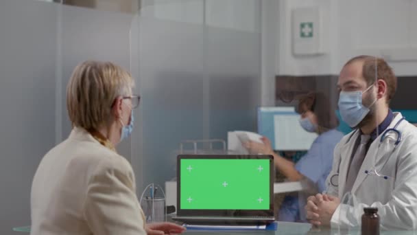 Starsza kobieta i lekarz patrząc na zielony ekran na laptopie — Wideo stockowe