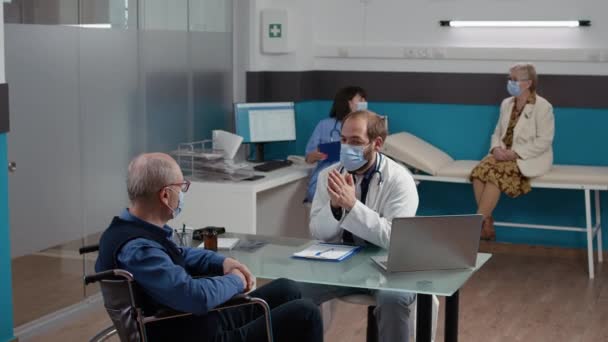 Médico haciendo consulta de chequeo con paciente en silla de ruedas — Vídeos de Stock