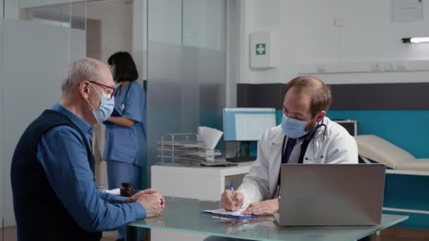 Health specialist giving prescription paper to senior patient — Stock Video