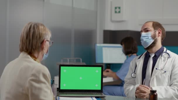Femme retraitée et médecin analysant ordinateur portable avec écran vert — Video