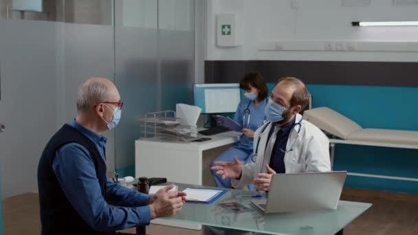 Mannelijke arts doet medisch overleg met oude patiënt — Stockvideo