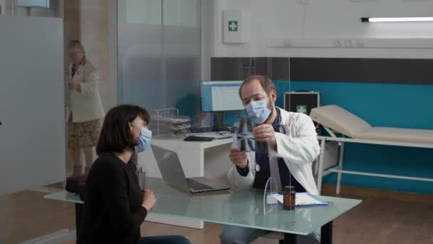 Médico masculino que explica el diagnóstico por rayos X a la mujer — Vídeos de Stock