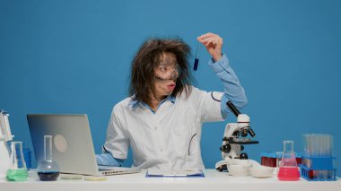 Masada test tüpündeki sıvıyı analiz eden çılgın bir kimyager.