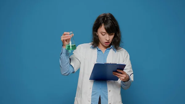 Científica analizando líquido en archivos de vasos de precipitados y química —  Fotos de Stock