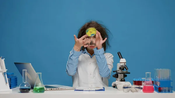 Смішний божевільний вчений дивиться на речовину в чашці Петрі — стокове фото