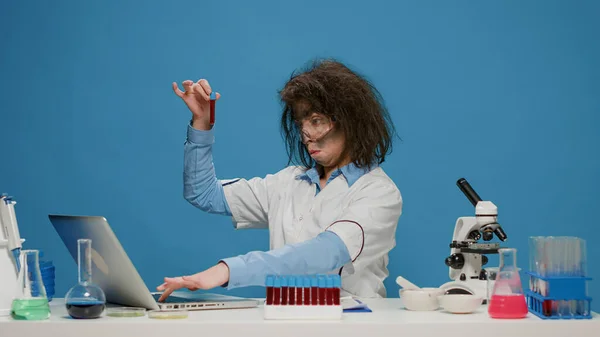 Rolig galen forskare med rörigt hår tittar på provrör — Stockfoto