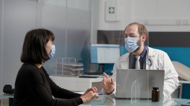 Hasta ve erkek doktor ofiste tıbbi danışmanlık yapıyorlar.