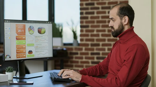 Mannelijke werknemer die op de computer om de verkoop winst te ontwikkelen — Stockfoto