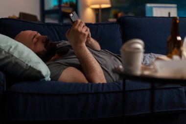 Akıllı telefon kullanan, kronik depresyonlu, sıkkın, üzgün kişi.