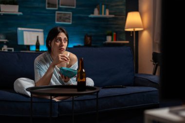 Kronik depresyonlu üzgün yalnız kadın televizyon programı izliyor.