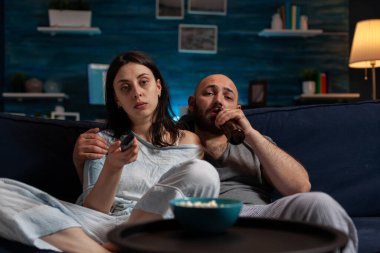 Kadın ve erkeğin TV uzaktan kumandayla kanal değiştirmesi