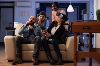 Video oyunları oynamak için vr kulaklık ve joystick kullanan ofis arkadaşları