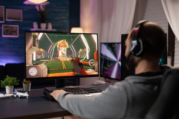 Volwassen met een koptelefoon die videospelletjes speelt op de computer — Stockfoto