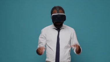 Kameranın önünde sanal gerçeklik gözlüğü takan genç adam.