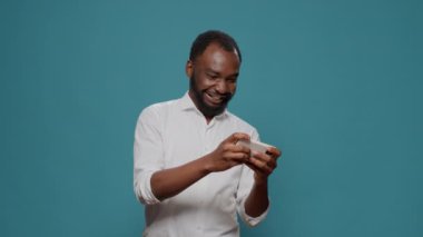 Akıllı telefondan mobil video oyunu oynayan erkek oyuncu