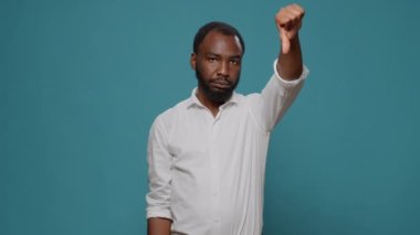 Negatif kişi stüdyoda baş parmak hareketi yapıyor.