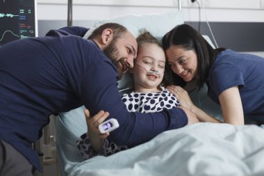 Neşeli mutlu ebeveynler birlikte oturup gülen küçük kızla