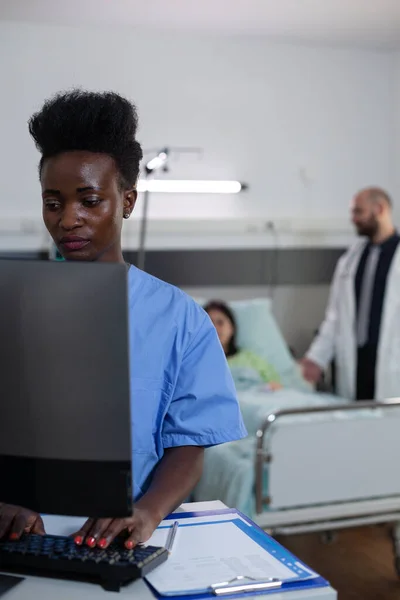 Ritratto di operatore sanitario afroamericano che utilizza il personal computer per leggere i risultati del laboratorio — Foto Stock