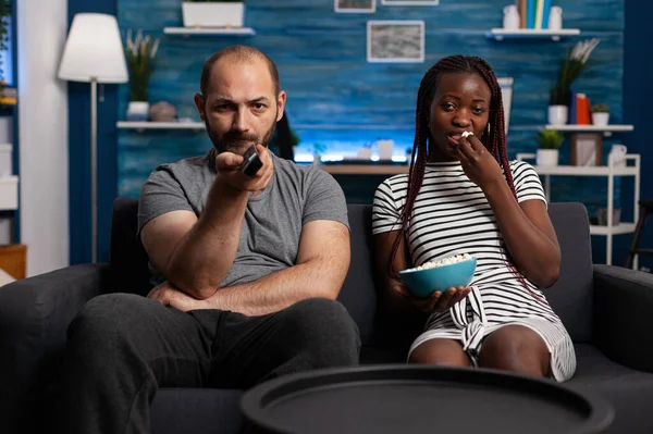 Uomo caucasico e donna afro-americana guardando la TV — Foto Stock