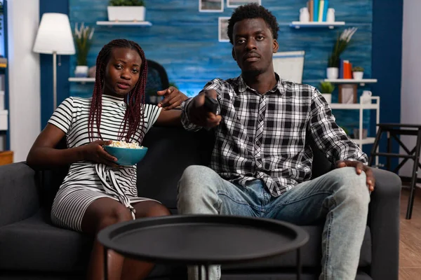 Afro-americana comendo pipocas no sofá — Fotografia de Stock