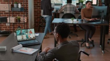 Genç adam internet telekonferansında iş adamlarıyla konuşuyor.