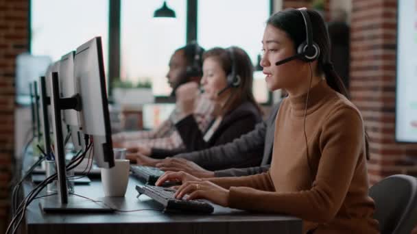 Aziatische vrouw met behulp van audio headset naar hebben gesprek op call center — Stockvideo