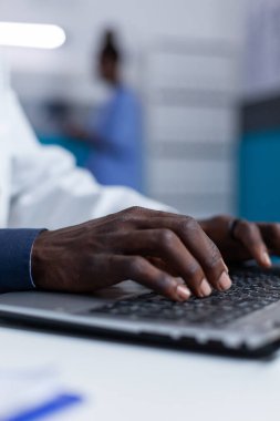 Hastane doktorunun hastaların kayıtlarını kontrol etmek için dizüstü bilgisayarı kullanması.