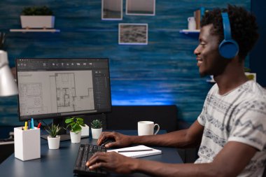 Gayrimenkul teknisyeni bilgisayarın önünde oturuyor.