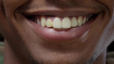 Kameranın önünde gülümseyen Afrikalı Amerikalı adamın makro çekimi.