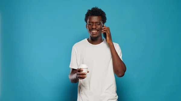 Portret van een man die een telefoongesprek beantwoordt op een smartphone in de studio — Stockfoto