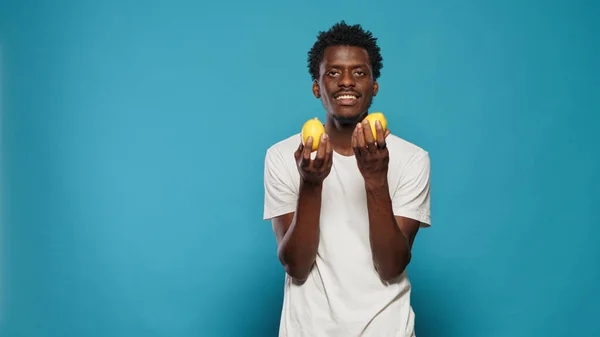 Personne joyeuse tenant des citrons pour une alimentation végétarienne saine — Photo