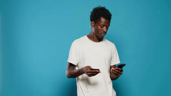 Young man using credit card for online shopping on smartphone — Stock Photo, Image
