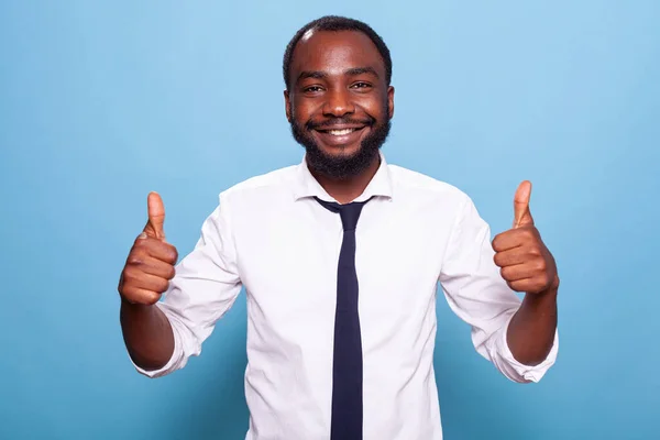 Портрет улыбающегося оптимиста в белой рубашке, показывающего два больших пальца вверх — стоковое фото