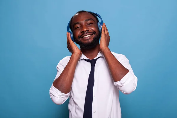 Sonriente hombre tocando auriculares inalámbricos se siente relajado disfrutando de la música agradable golpe superior — Foto de Stock