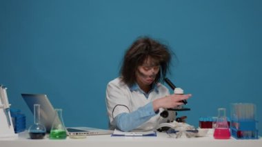 Masada mikroskop kullanan çatlak bir kadın araştırmacı.