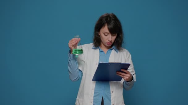 Cientista feminina analisando líquido em arquivos de beaker e química — Vídeo de Stock