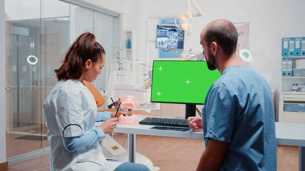 Homem e mulher trabalhando com tela verde e layout de dentes — Fotografia de Stock